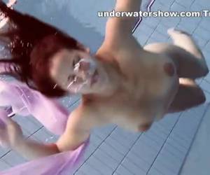Un video porno XXX elegante de joven desnuda bajo agua . Pelirroja de pelo largo Paulinka haciendo un espectaculo submarino desnudándose completamente mientras está bajo del agua en la piscina .